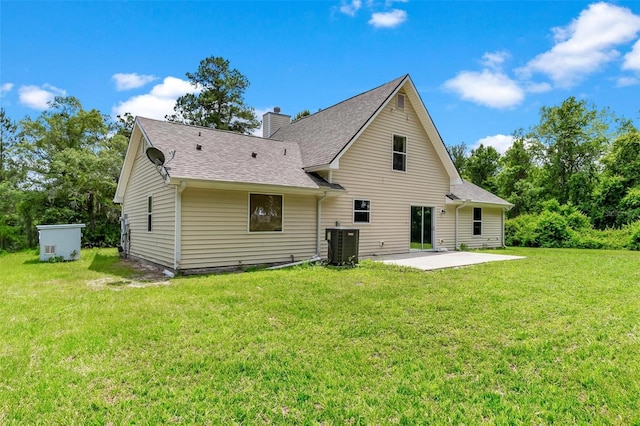 rear view of property with a patio, a yard, and central air condition unit