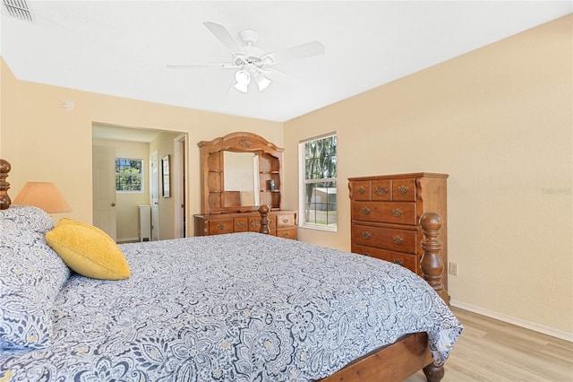 bedroom featuring ceiling fan, light wood-type flooring, and multiple windows