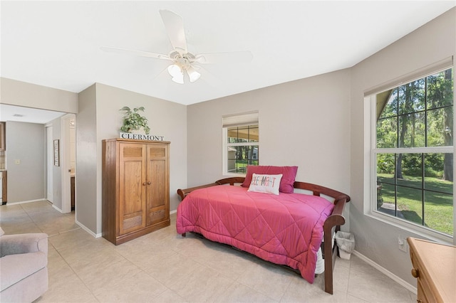 tiled bedroom featuring ceiling fan and multiple windows