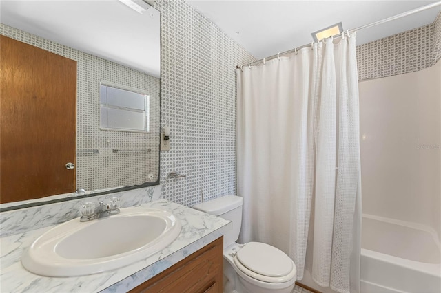 full bathroom with shower / tub combo, toilet, and vanity with extensive cabinet space