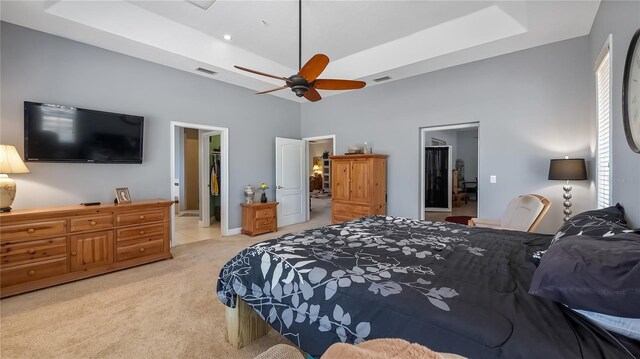 23321 N Buckhill Rd, Howey In The Hills, FL 34737 - bedroom with a tray ceiling, light carpet, ensuite bathroom, a towering ceiling, and a ceiling fan