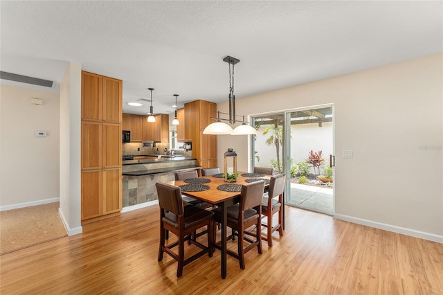 dining space with light hardwood / wood-style floors and sink