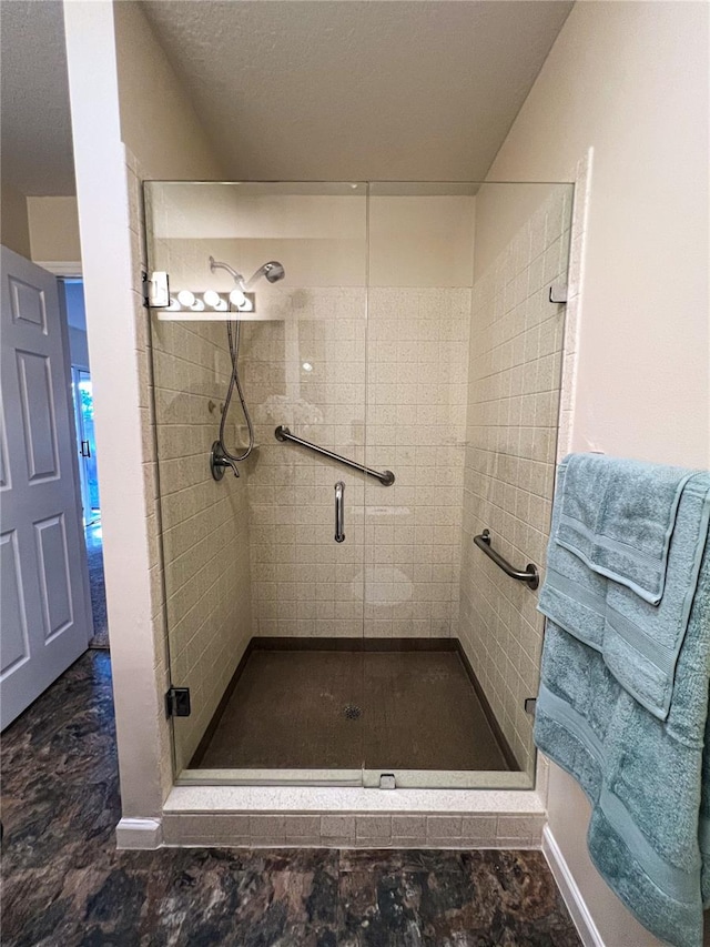 bathroom with tile flooring, an enclosed shower, and a textured ceiling