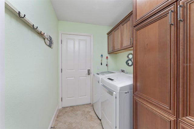 laundry room with cabinets, light tile patterned floors, and separate washer and dryer