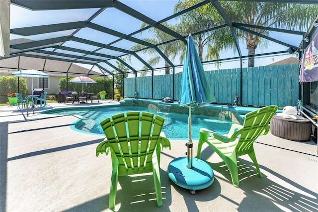 view of swimming pool with pool water feature, glass enclosure, and a patio area