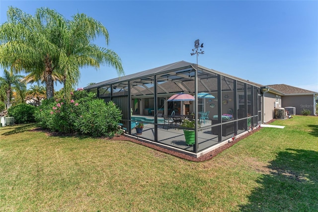 back of property featuring a lanai, central AC, a yard, and a patio