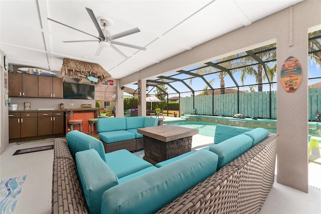 view of patio featuring a lanai, an outdoor living space, an outdoor bar, and ceiling fan