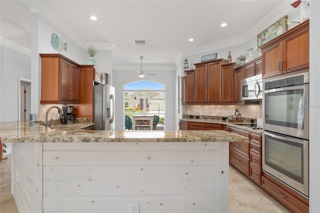 kitchen with appliances with stainless steel finishes, ornamental molding, kitchen peninsula, and light stone counters