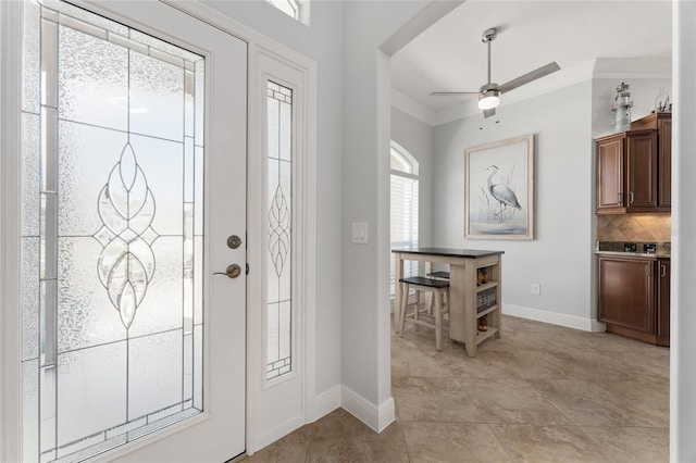 foyer with ceiling fan, light tile patterned floors, and crown molding