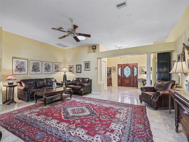 living room with ornate columns, ceiling fan, a textured ceiling, and light tile flooring