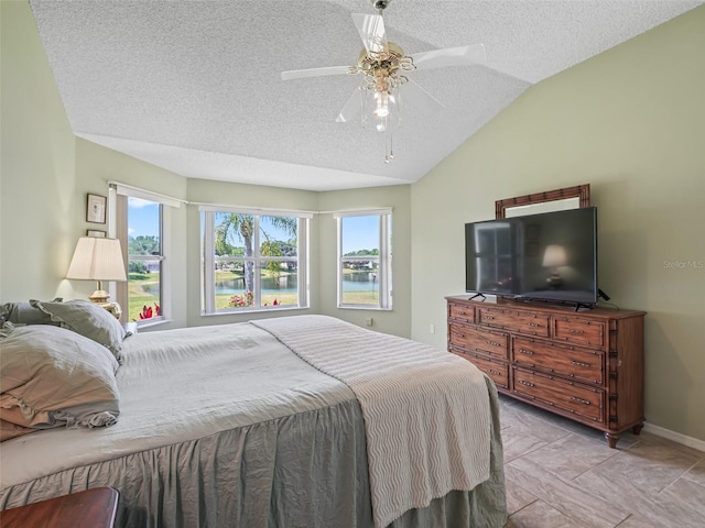 tiled bedroom featuring vaulted ceiling, ceiling fan, and a textured ceiling