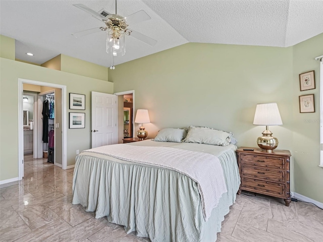 tiled bedroom featuring lofted ceiling, ceiling fan, a walk in closet, and a textured ceiling