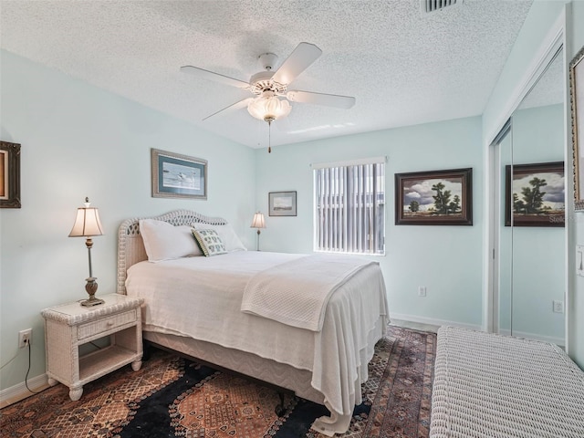 bedroom with a textured ceiling and ceiling fan