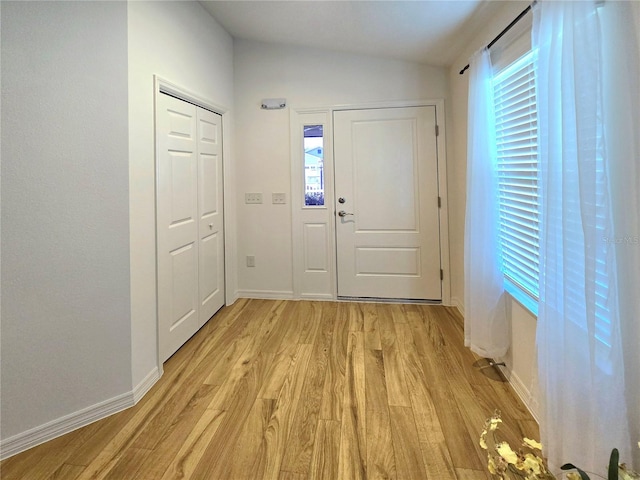 entryway with a wealth of natural light, light hardwood / wood-style flooring, and lofted ceiling