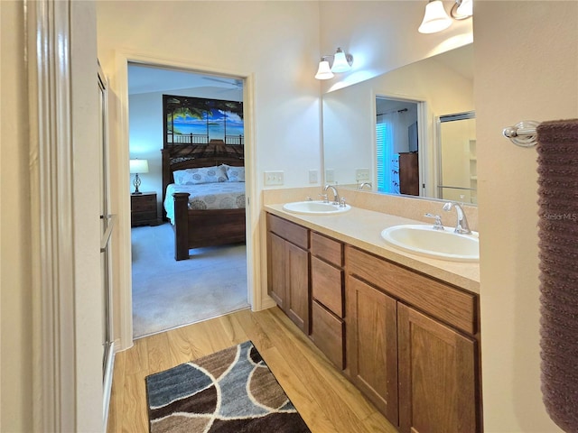 bathroom with double sink, an enclosed shower, hardwood / wood-style floors, and large vanity