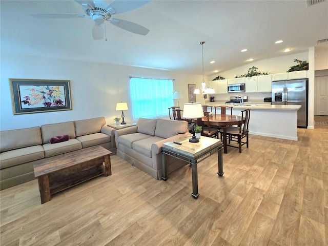 living room with light hardwood / wood-style flooring, ceiling fan, and vaulted ceiling