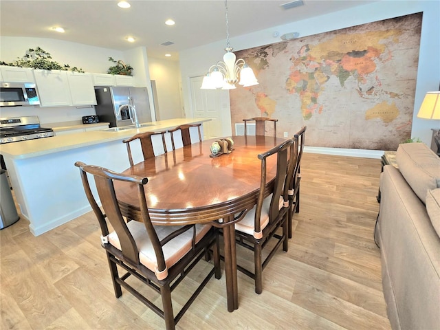 dining space featuring light hardwood / wood-style floors and a chandelier