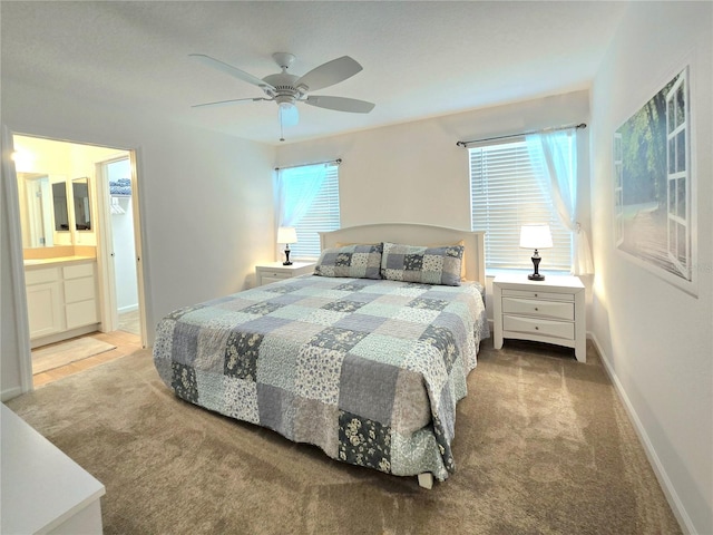 carpeted bedroom with ceiling fan and ensuite bathroom