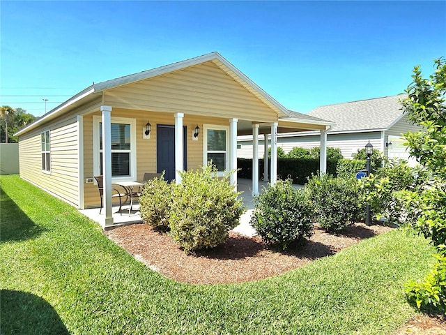 view of front of home with a porch and a front yard