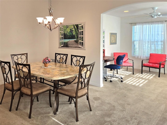 dining space with ceiling fan with notable chandelier and carpet