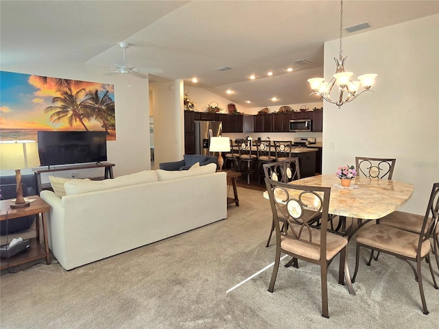 dining area featuring light carpet, lofted ceiling, and ceiling fan with notable chandelier