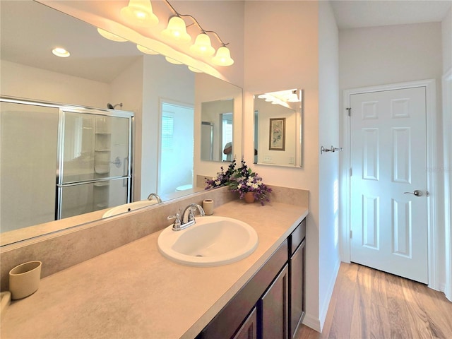 bathroom featuring walk in shower, hardwood / wood-style floors, and large vanity