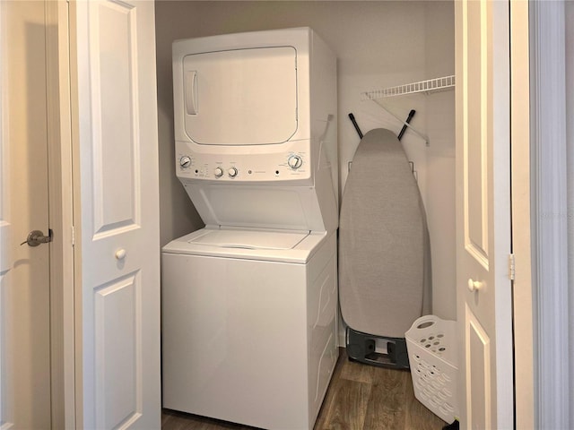 washroom featuring stacked washer and dryer and dark hardwood / wood-style floors