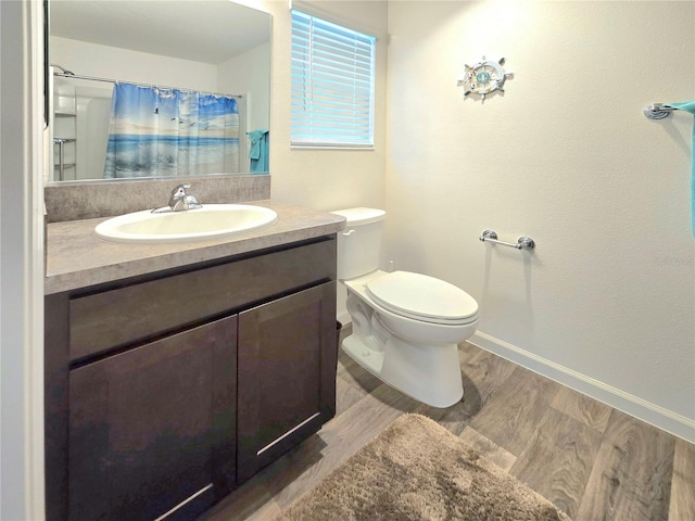 bathroom with oversized vanity, toilet, and hardwood / wood-style flooring