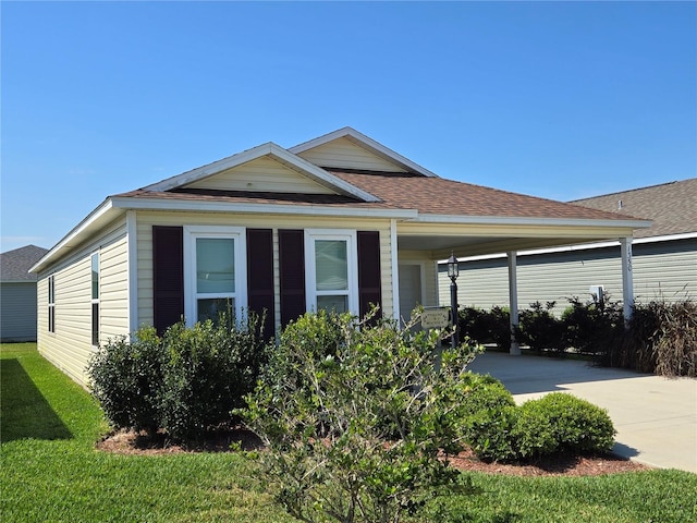 view of front of house with a carport and a front lawn