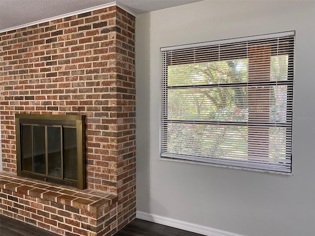 room details featuring hardwood / wood-style floors, a textured ceiling, and a brick fireplace