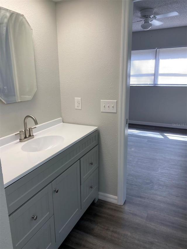 bathroom featuring ceiling fan, hardwood / wood-style floors, vanity, and a textured ceiling