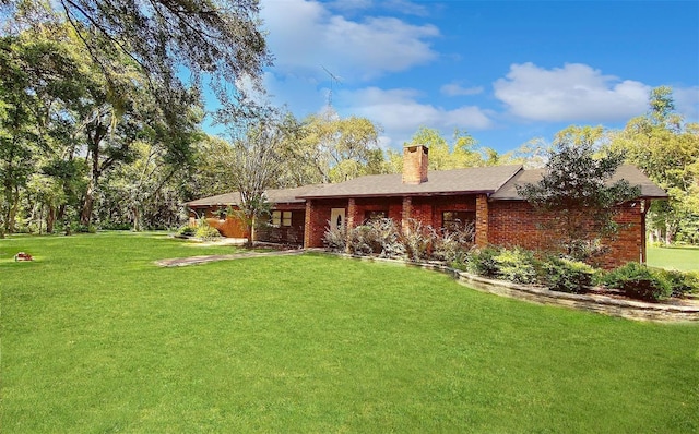 1921 Smitty Rd, Weirsdale, FL 32195 - back of house with a lawn, a chimney, and brick siding