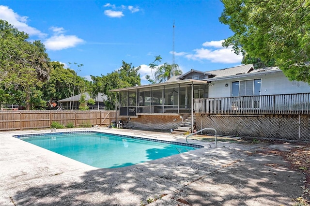 view of swimming pool featuring a sunroom and a patio