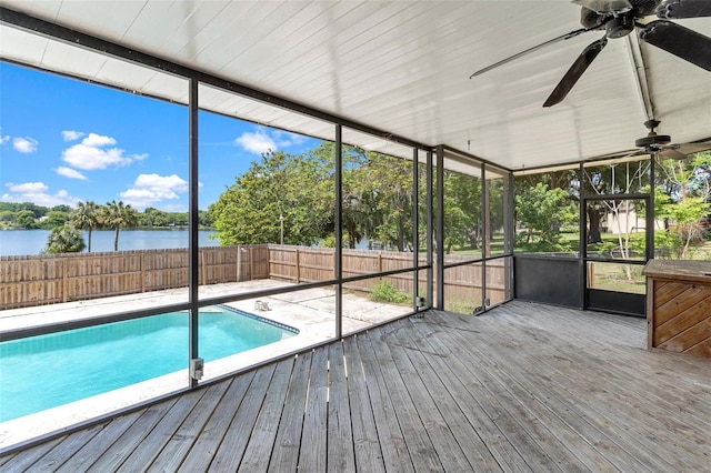 unfurnished sunroom featuring ceiling fan and a water view