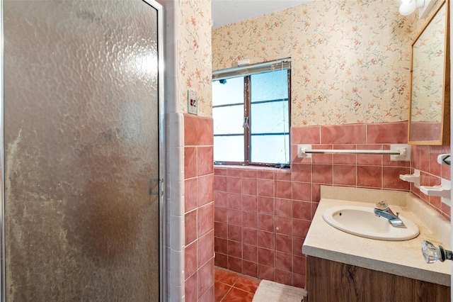 bathroom featuring walk in shower, vanity, tile patterned floors, and tile walls