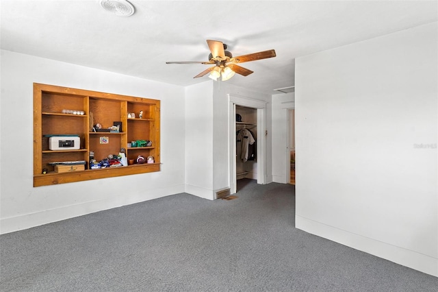 carpeted empty room with ceiling fan and built in features