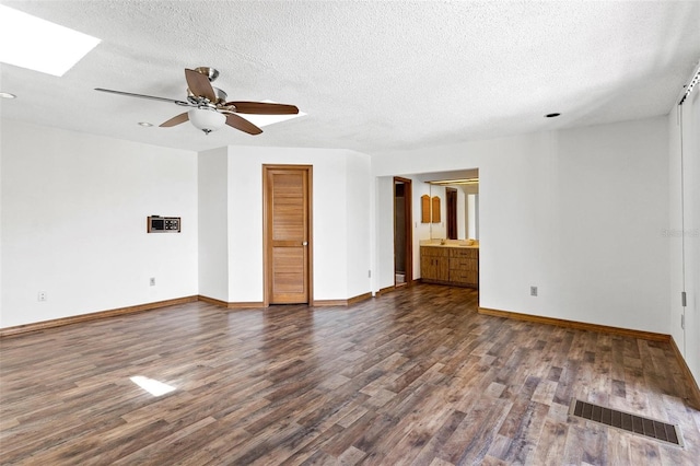 empty room featuring ceiling fan, dark hardwood / wood-style flooring, and a textured ceiling