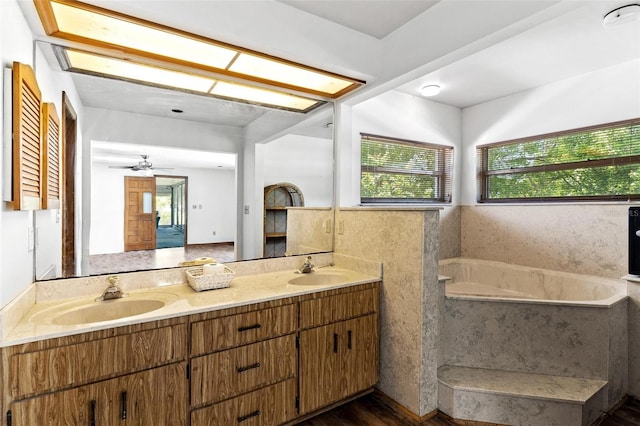 bathroom with ceiling fan, hardwood / wood-style floors, vanity, and a bath