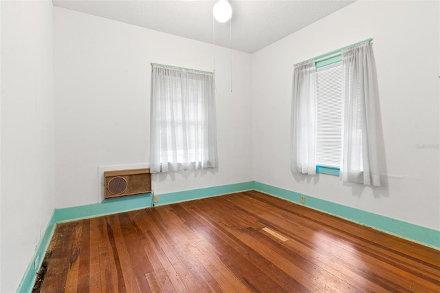 spare room with wood-type flooring and heating unit