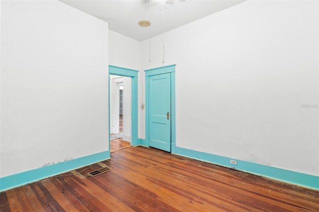 spare room featuring wood-type flooring and a textured ceiling