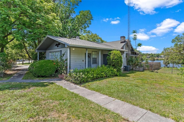 view of front of property with central AC and a front yard