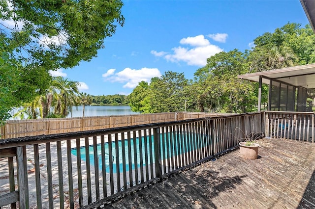 view of pool with a sunroom and a water view