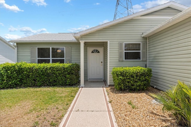 property entrance featuring a lawn