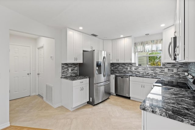 kitchen featuring white cabinets, sink, dark stone countertops, and stainless steel appliances