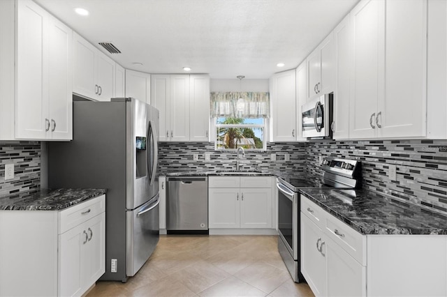 kitchen with backsplash, sink, white cabinets, and appliances with stainless steel finishes