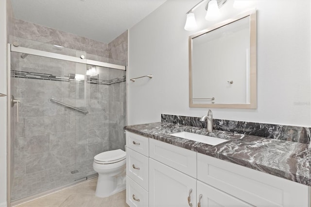 bathroom with walk in shower, tile patterned flooring, vanity, and toilet