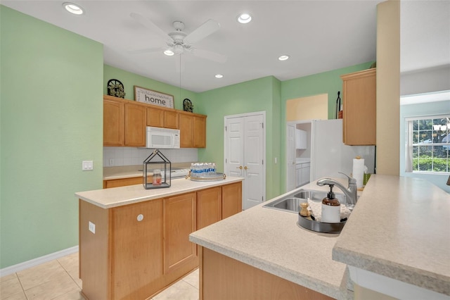 kitchen featuring backsplash, a kitchen island, white appliances, ceiling fan, and sink