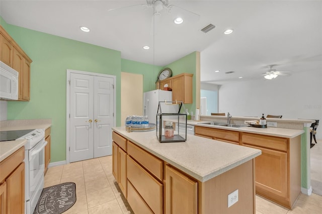 kitchen featuring sink, ceiling fan, a kitchen island, and white appliances