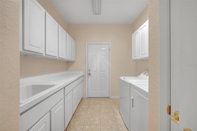 laundry room featuring sink, cabinets, light tile floors, and washer and clothes dryer