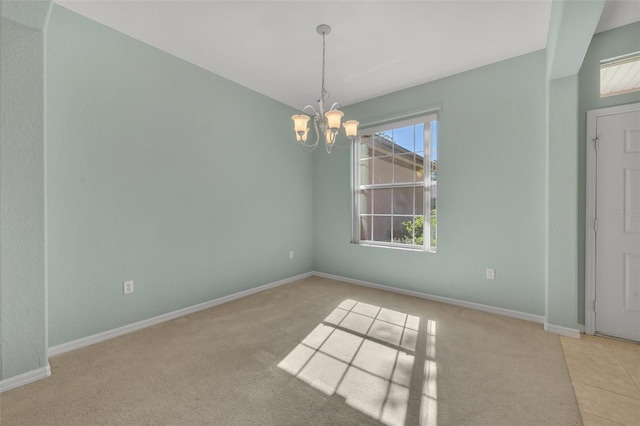 carpeted spare room with a notable chandelier